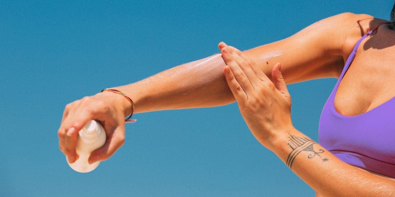 closeup of woman's arm applying a sunscreen